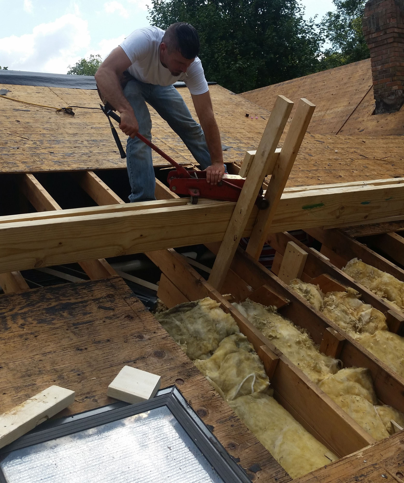In this photo, our company founder uses a floor jack and jig to 'pull' framing into place